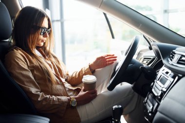 Modern otomobilinin içindeki şık, güzel genç bayanın yan görüntüsü..