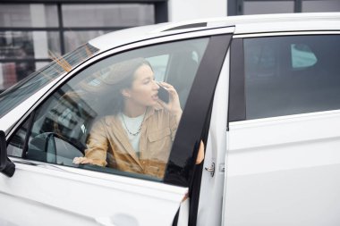 Kapılı telefon konuşmaları açıldı. Modaya uygun genç bir kadın ve modern arabası..