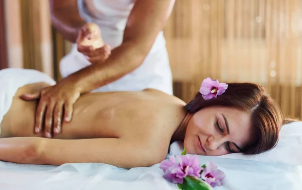 Purple Flower Lying Man Does Massage Young Woman White Towel — Stock Photo, Image