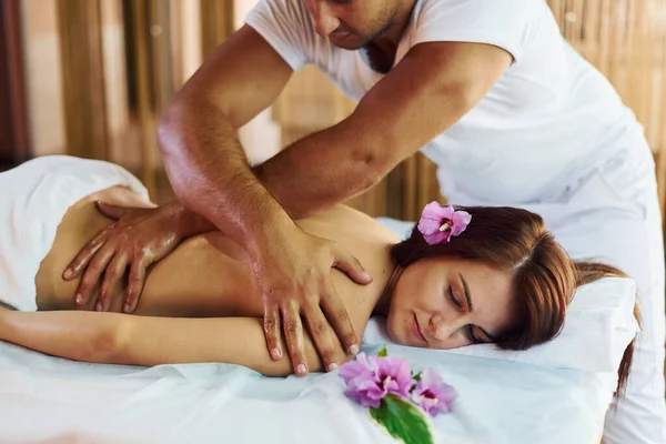Flor Roxa Deitada Homem Faz Massagem Para Jovem Mulher Toalha — Fotografia de Stock