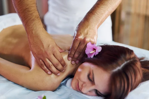 Flor Roxa Deitada Homem Faz Massagem Para Jovem Mulher Toalha — Fotografia de Stock