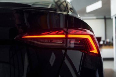 Arabanın arka görüntüsü. Yepyeni siyah otomobilin odaklanmış görüntüsünü kapat.