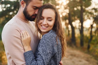 Birbirlerine sarılırlar. Neşeli genç çift dışarıda birlikte dinleniyor..