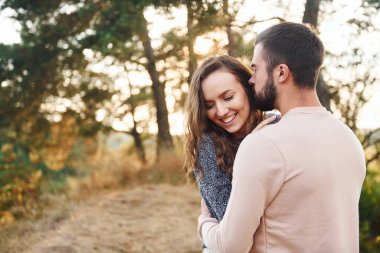 Birbirlerine sarılırlar. Neşeli genç çift dışarıda birlikte dinleniyor..