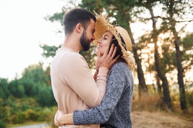 Birbirlerine sarılırlar. Neşeli genç çift dışarıda birlikte dinleniyor..