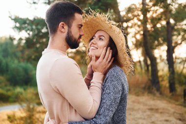 Ayakta durup sarılıyor. Neşeli genç çift dışarıda birlikte dinleniyor..