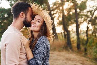 Ayakta durup sarılıyor. Neşeli genç çift dışarıda birlikte dinleniyor..
