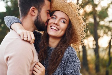 Ayakta durup sarılıyor. Neşeli genç çift dışarıda birlikte dinleniyor..