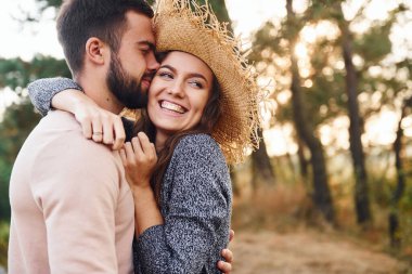 Ayakta durup sarılıyor. Neşeli genç çift dışarıda birlikte dinleniyor..