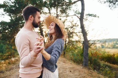 Ayakta durup sarılıyor. Neşeli genç çift dışarıda birlikte dinleniyor..