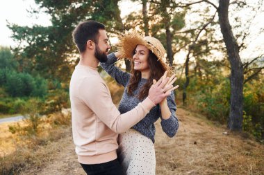 Ayakta durup sarılıyor. Neşeli genç çift dışarıda birlikte dinleniyor..