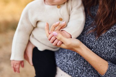 Manzarayı kapat. Yavrusu olan genç anne sonbahar mevsiminde dışarıda dinleniyor..
