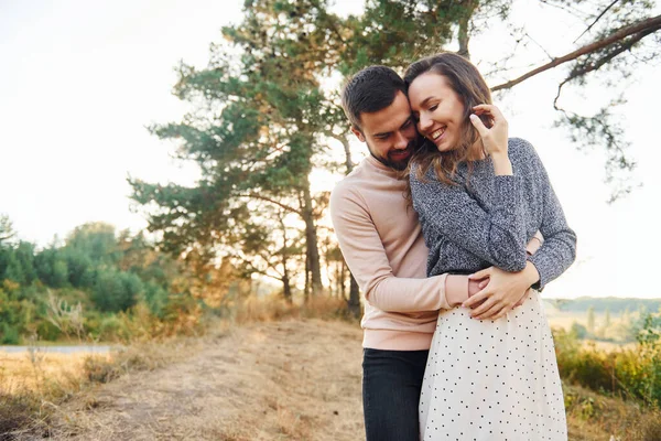 Birbirlerine sarılırlar. Neşeli genç çift dışarıda birlikte dinleniyor..