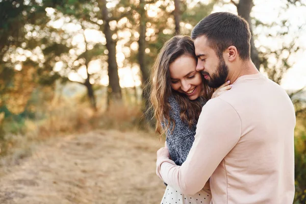 Birbirlerine sarılırlar. Neşeli genç çift dışarıda birlikte dinleniyor..