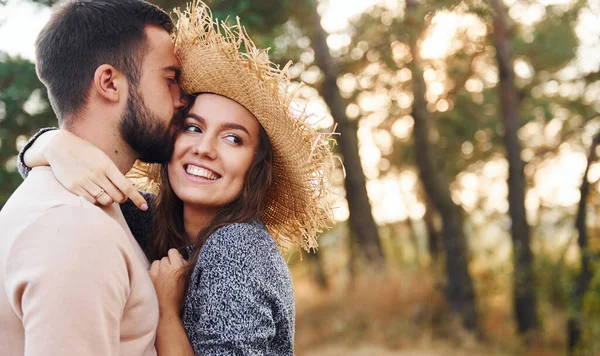 Ayakta durup sarılıyor. Neşeli genç çift dışarıda birlikte dinleniyor..