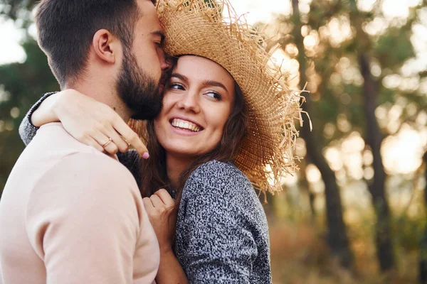 Ayakta durup sarılıyor. Neşeli genç çift dışarıda birlikte dinleniyor..