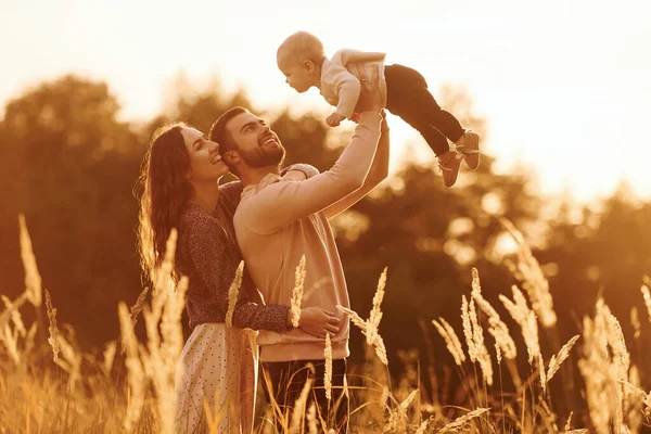 太陽の光に照らされる そして小さな赤ちゃんの幸せな家族は屋外にいます 美しい晴れた秋の自然 — ストック写真