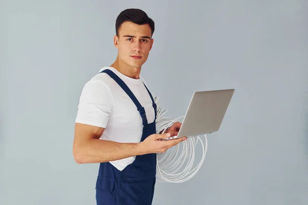 Usa Portátil Hombre Trabajador Uniforme Azul Pie Dentro Del Estudio —  Fotos de Stock