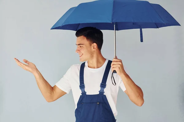 Hält Regenschirm Von Hand Männlicher Arbeiter Blauer Uniform Steht Atelier — Stockfoto