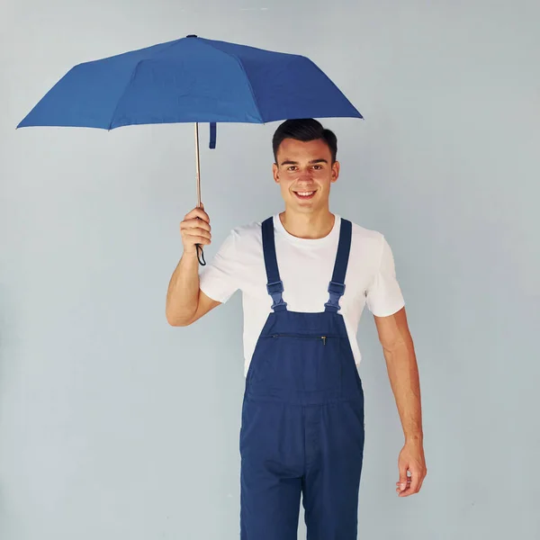 Hält Regenschirm Von Hand Männlicher Arbeiter Blauer Uniform Steht Atelier — Stockfoto