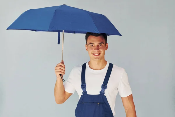 Hält Regenschirm Von Hand Männlicher Arbeiter Blauer Uniform Steht Atelier — Stockfoto