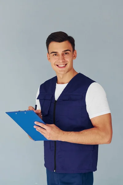 Schreibt Notizblock Männlicher Arbeiter Blauer Uniform Steht Atelier Vor Weißem — Stockfoto