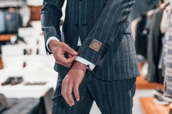 Manzarayı kapat. Modern mağazada yeni kıyafetleri olan genç bir adam. Erkekler için pahalı bir elbise..