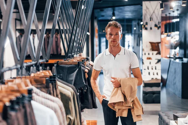 Busca Chaqueta Joven Una Tienda Moderna Con Ropa Nueva Elegante — Foto de Stock