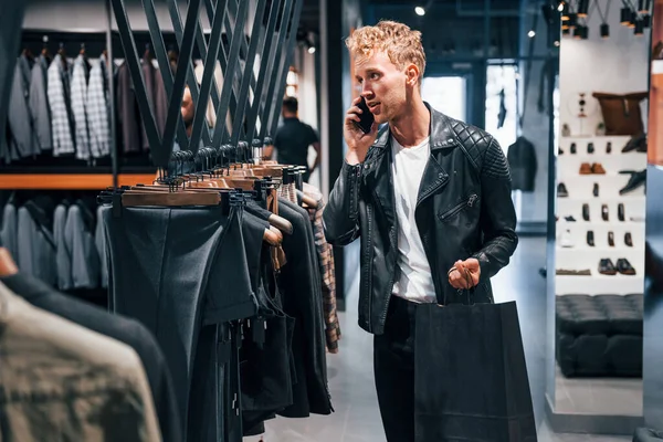 Habla Por Teléfono Joven Una Tienda Moderna Con Ropa Nueva — Foto de Stock