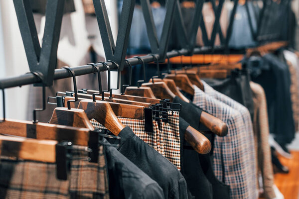 Стильная новая одежда в современном магазине. Элегантная одежда для мужчин.