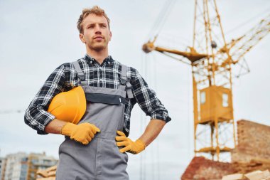 Mola veriyor. Üniformalı inşaat işçisi ve güvenlik ekipmanı inşaatında çalışıyor.