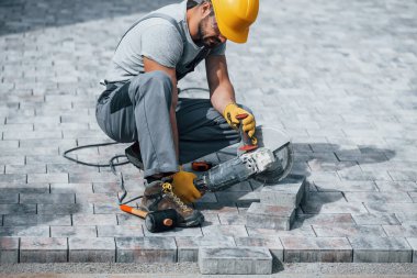 İşine odaklan. Sarı üniformalı adamın kaldırımlı bir işi var..