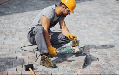 İşine odaklan. Sarı üniformalı adamın kaldırımlı bir işi var..