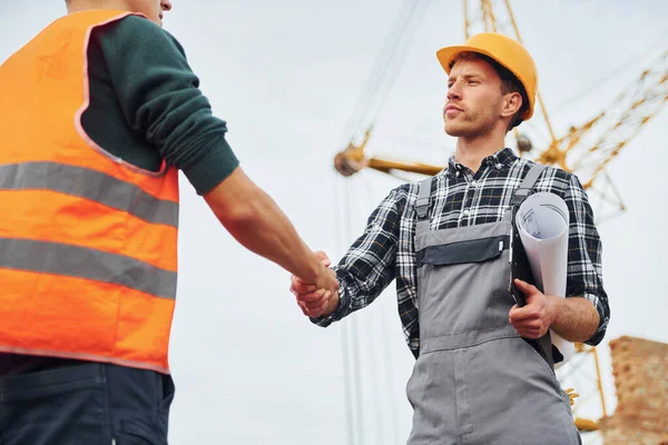 Händeschütteln Zwei Bauarbeiter Uniform Und Sicherheitsausrüstung Haben Gemeinsam Bauen — Stockfoto