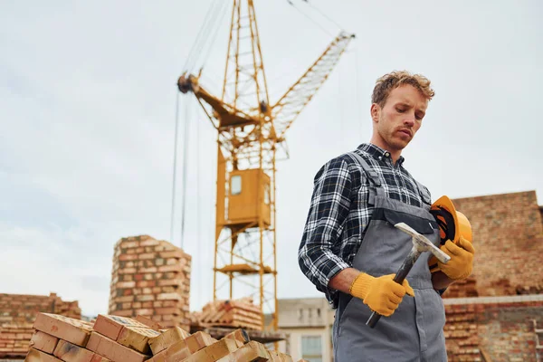 Stående Holder Hard Hatt Med Hammer Bygningsarbeider Uniform Sikkerhetsutstyr Har – stockfoto