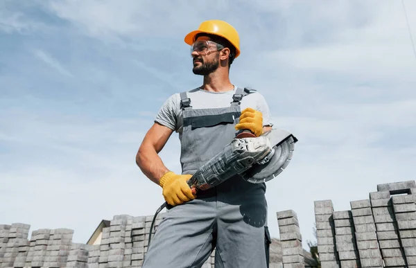 Att Välja Kamera Med Cirkelsåg Manlig Arbetare Gul Färgad Uniform — Stockfoto