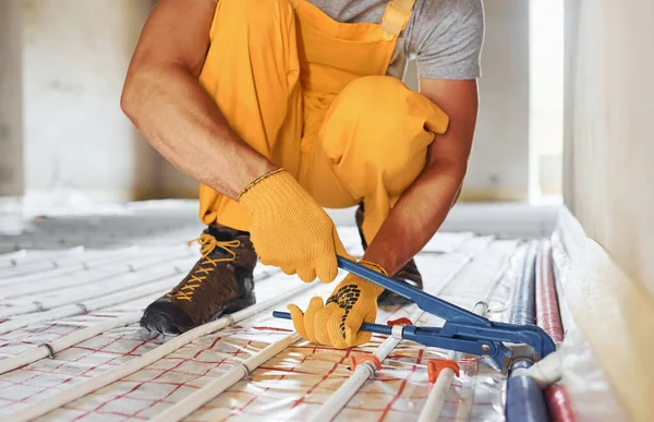 Bitmek üzere. Sarı üniformalı işçiler zemin altı ısıtma sistemi kuruyor.