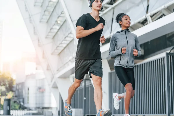 European man and african american woman in sportive clothes have workout together.