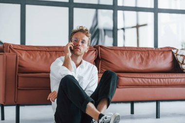 Dinleniyorum. Beyaz, zarif beyaz gömlekli beyaz adam evde..