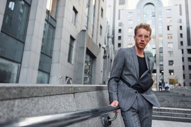 Şık giyinmiş genç bir adam gündüz vakti şehir dışında..