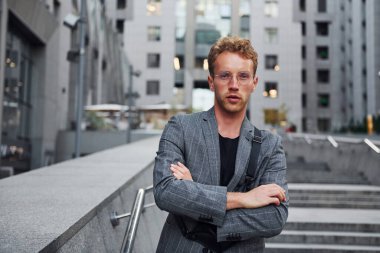 Şık giyinmiş genç bir adam gündüz vakti şehir dışında..