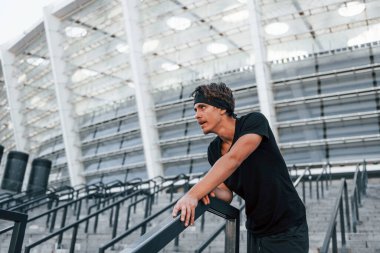 Spor elbiseli genç adam gündüz vakti dışarıda antrenman yapıyor..