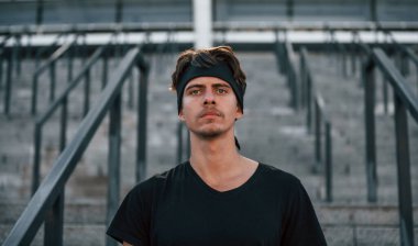 Spor elbiseli genç bir adamın portresi. Gündüz dışarıda spor yapıyorlar..