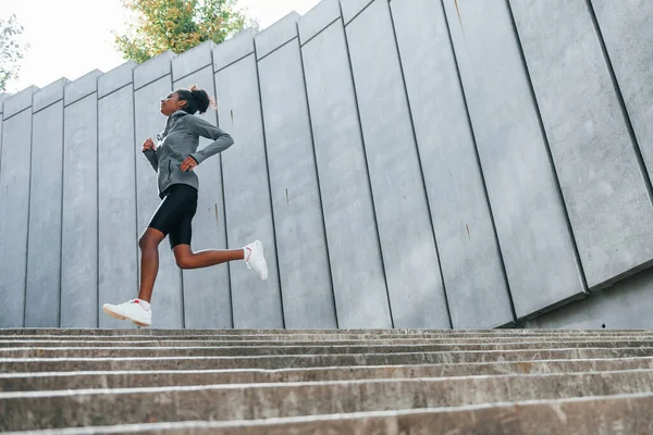 身穿运动服的年轻非洲裔美国妇女白天在室外锻炼 — 图库照片