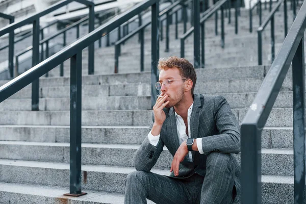 Zit Rookt Een Sigaret Jonge Succesvolle Zakenman Grijze Formele Kleding — Stockfoto