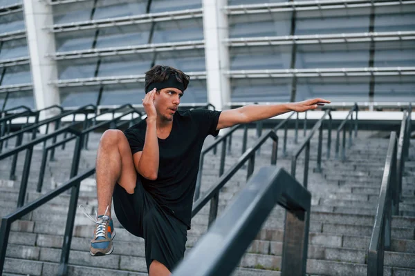 Koşmak ve zıplamak. Spor elbiseli genç adam gündüz vakti dışarıda antrenman yapıyor..