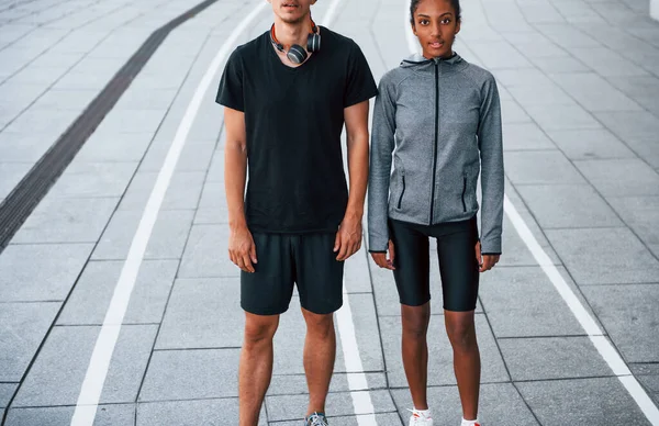 European man and african american woman in sportive clothes have workout together.