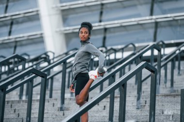 Merdivenlerde. Spor elbiseli genç Afrikalı Amerikalı kadın gündüzleri dışarıda antrenman yapıyor..