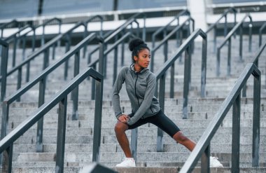Merdivenlerde. Spor elbiseli genç Afrikalı Amerikalı kadın gündüzleri dışarıda antrenman yapıyor..