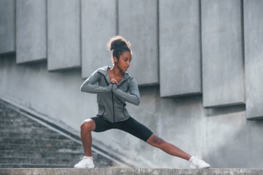 Spor anlayışı. Spor elbiseli genç Afrikalı Amerikalı kadın gündüzleri dışarıda antrenman yapıyor..